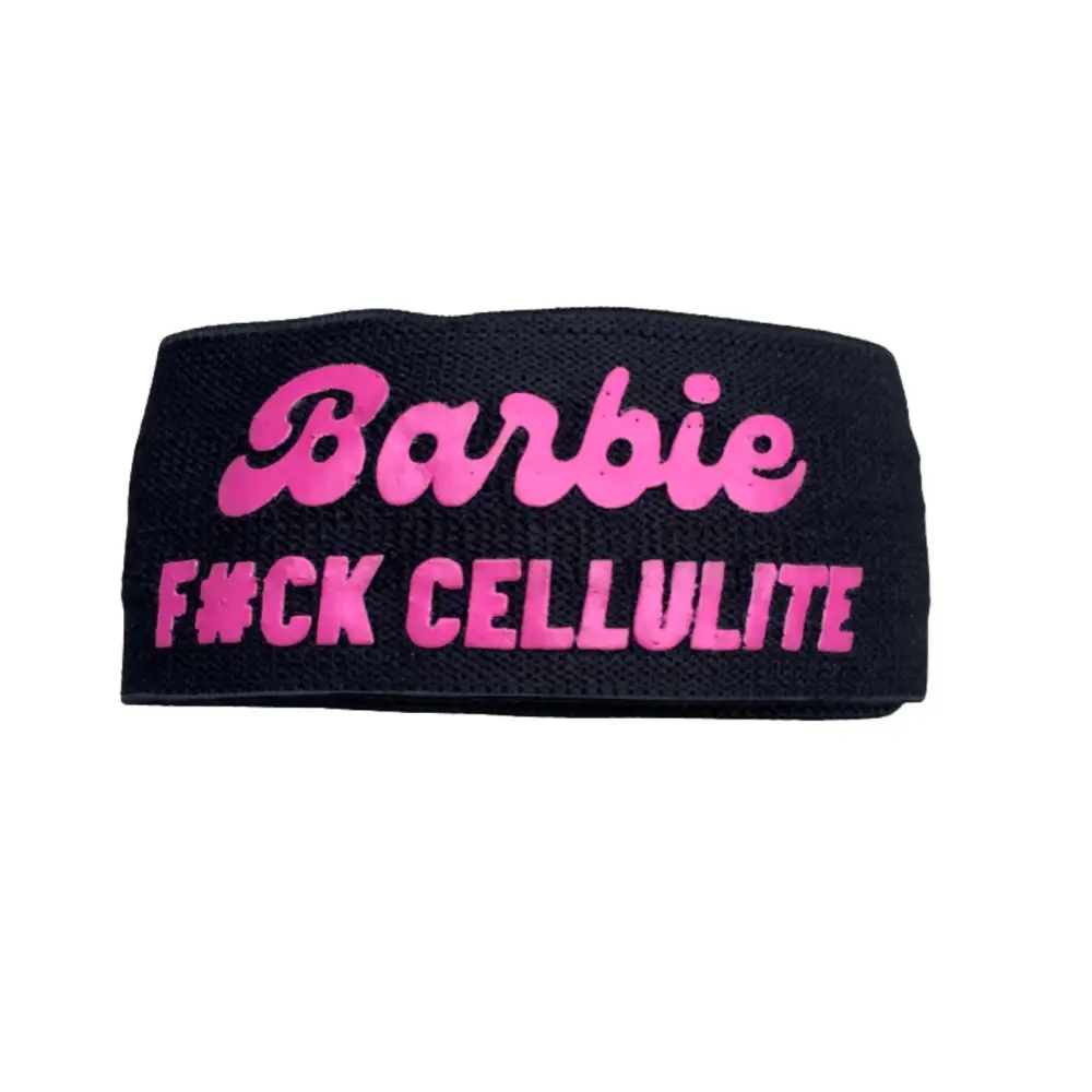 Zwarte hoofdband met roze tekst ’Barbie F*CK CELLULITE’.